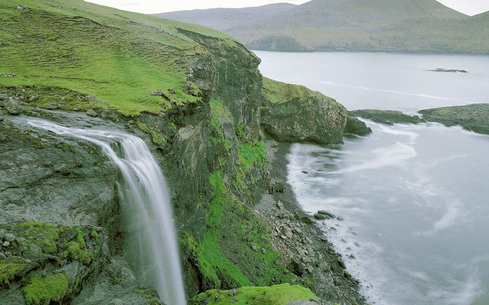 Waterfall on a green cliff