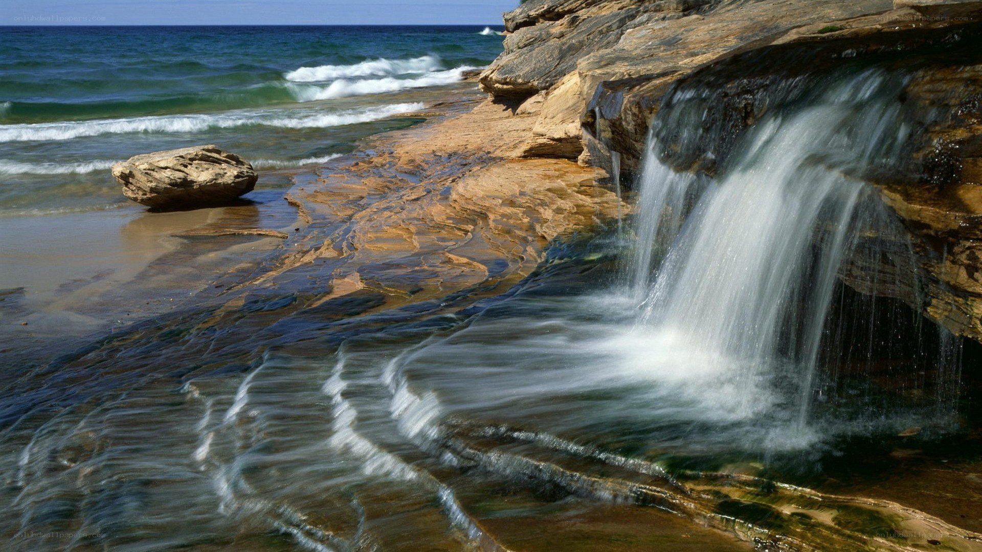 Waterfall on rocky beach