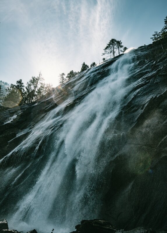 Waterfall on Rocky Cliff — Blue, Dramatic, Afternoon, Photograph, Trees, Sky, Rocks