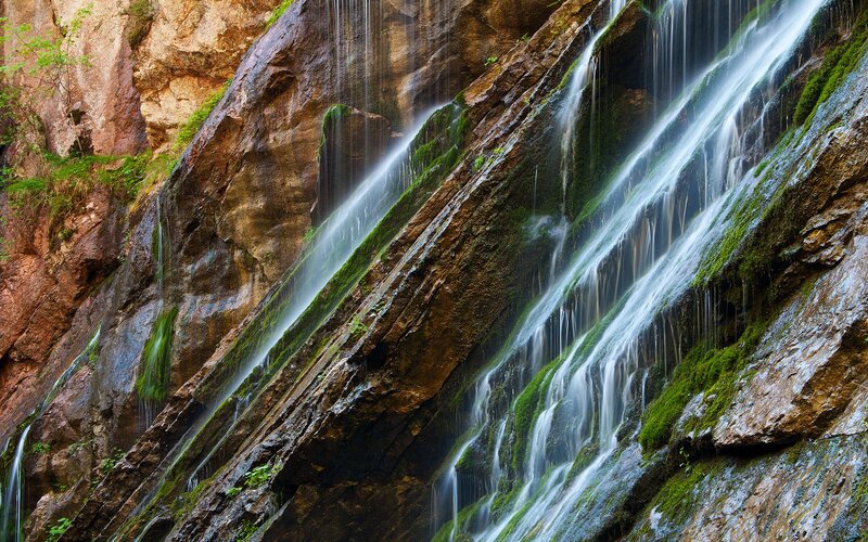 Waterfall on Rocky Cliff — Green, Serene, Afternoon, Photograph, Rock