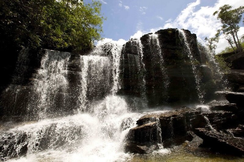 Waterfall on Rocky Cliff — Green, Serene, Afternoon, Photograph, Trees, Rocks, Sky, Blue