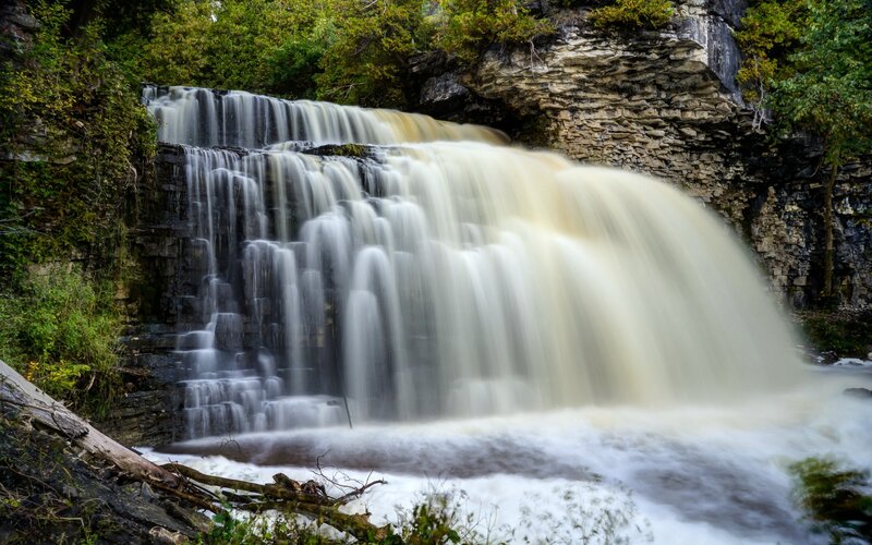 Waterfall on Rocky Cliff — Green, Serene, Autumn, Photograph, Trees, Rocks, River