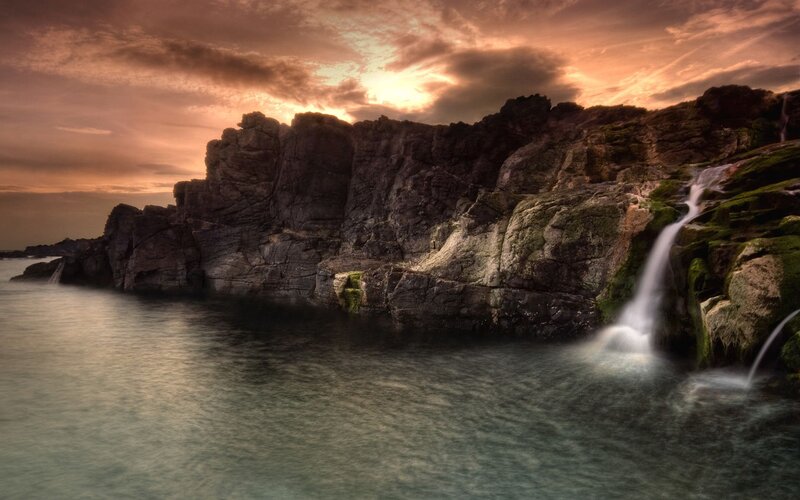Waterfall on Rocky Cliff — Orange, Dramatic, Sunset, Photograph, Ocean, Sky