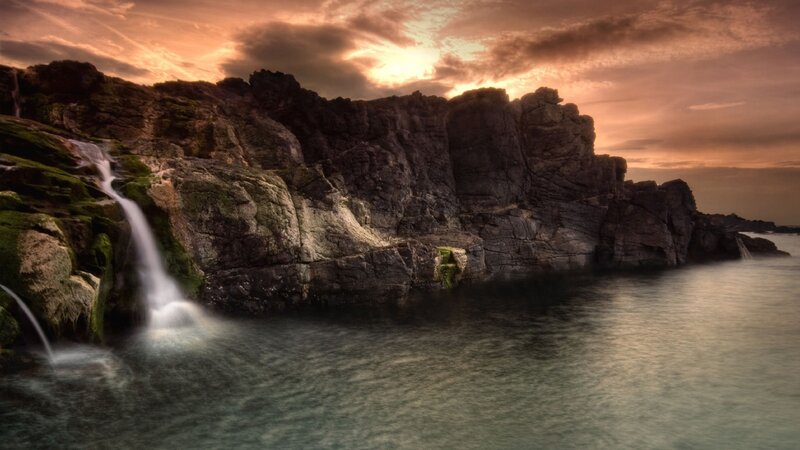 Waterfall on Rocky Coast — Orange, Dramatic, Sunset, Photograph