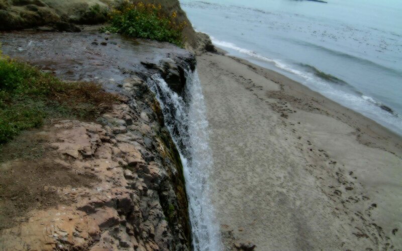 Waterfall on sandy beach