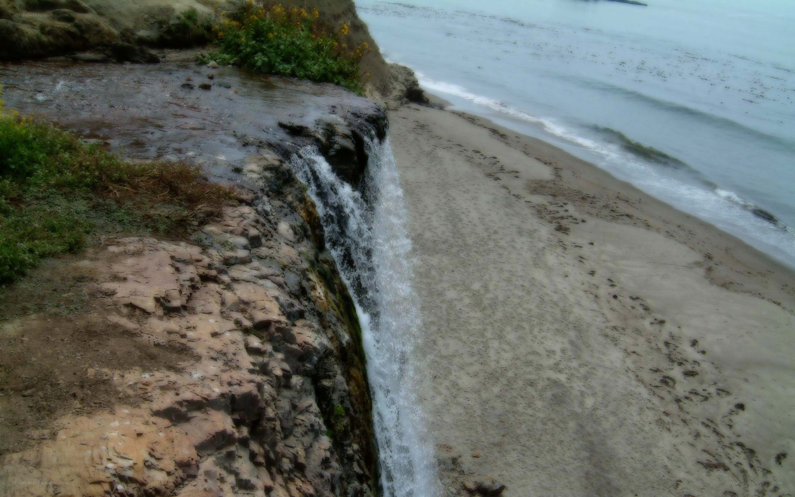 Waterfall on sandy beach