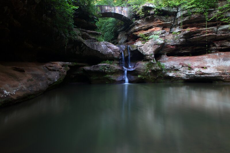 Waterfall under a stone bridge