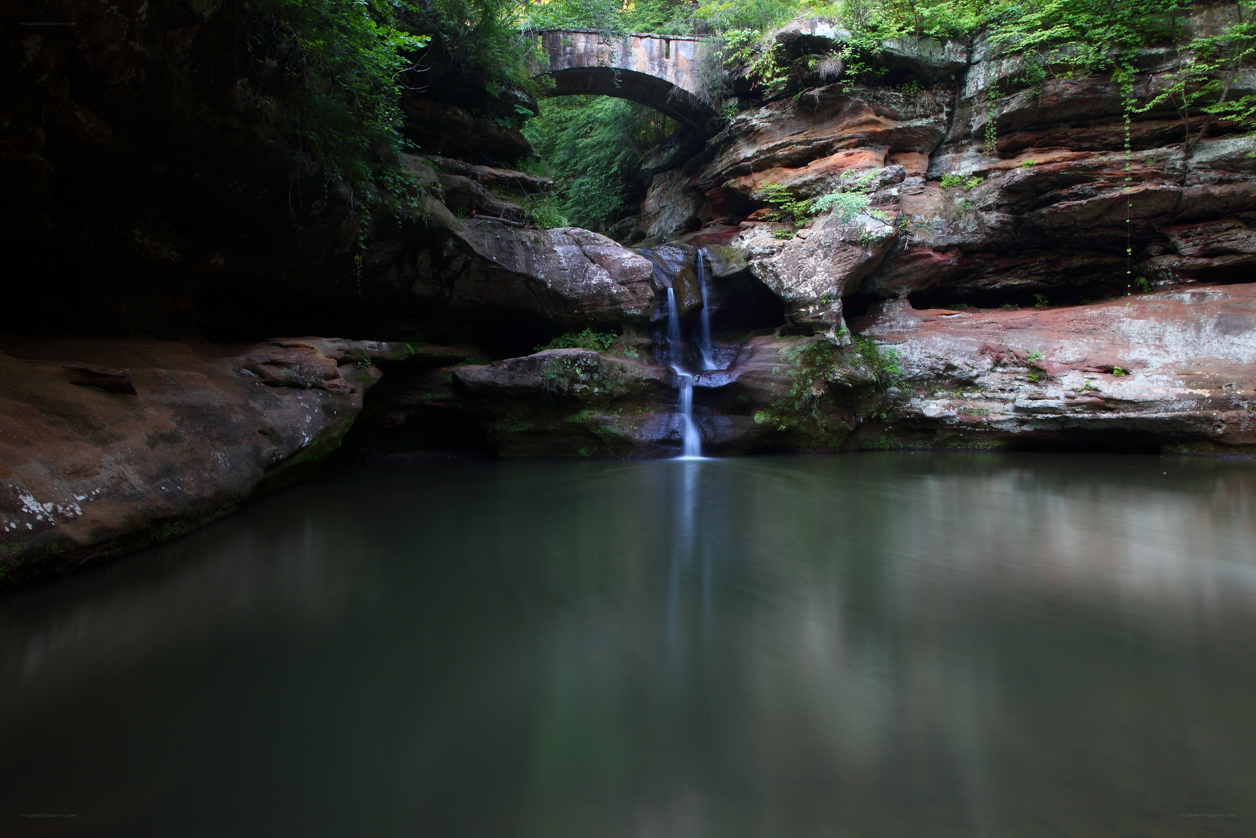 Waterfall under a stone bridge