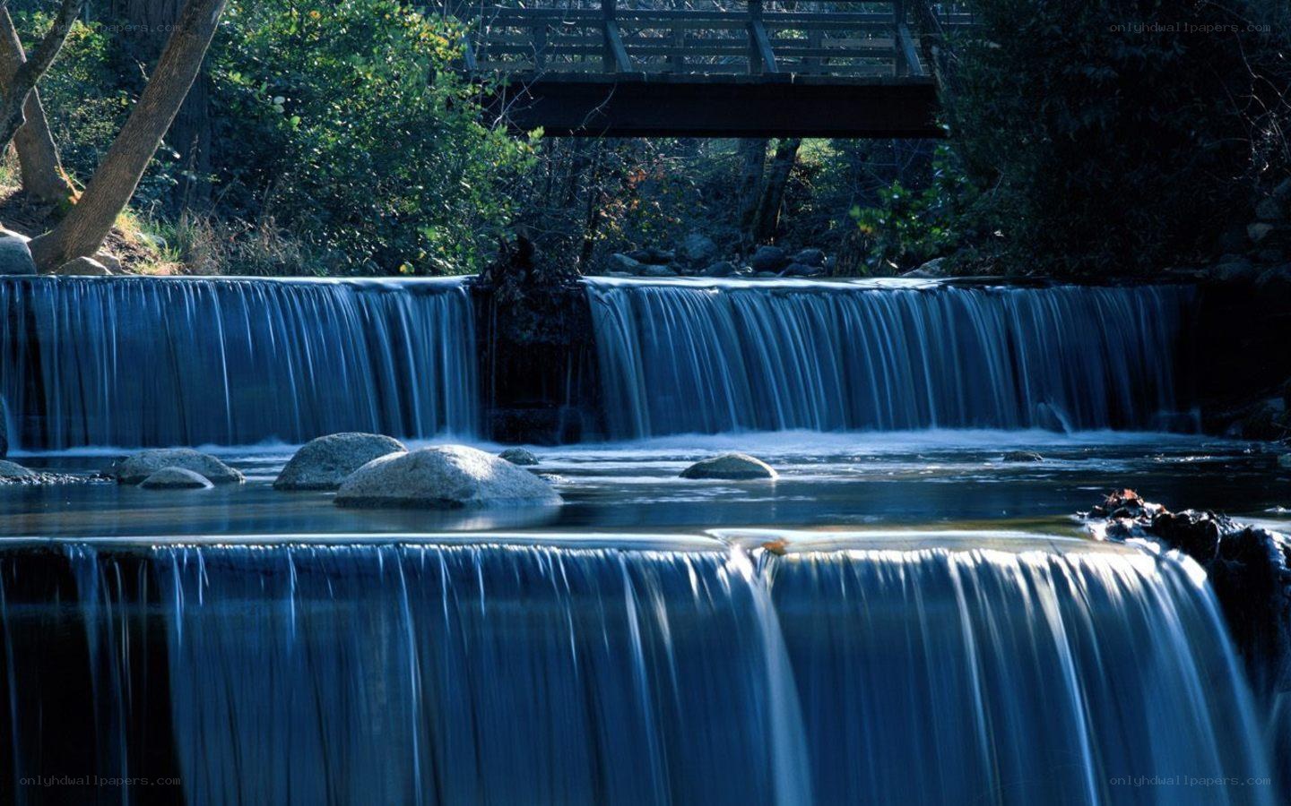 Waterfall under a wooden bridge