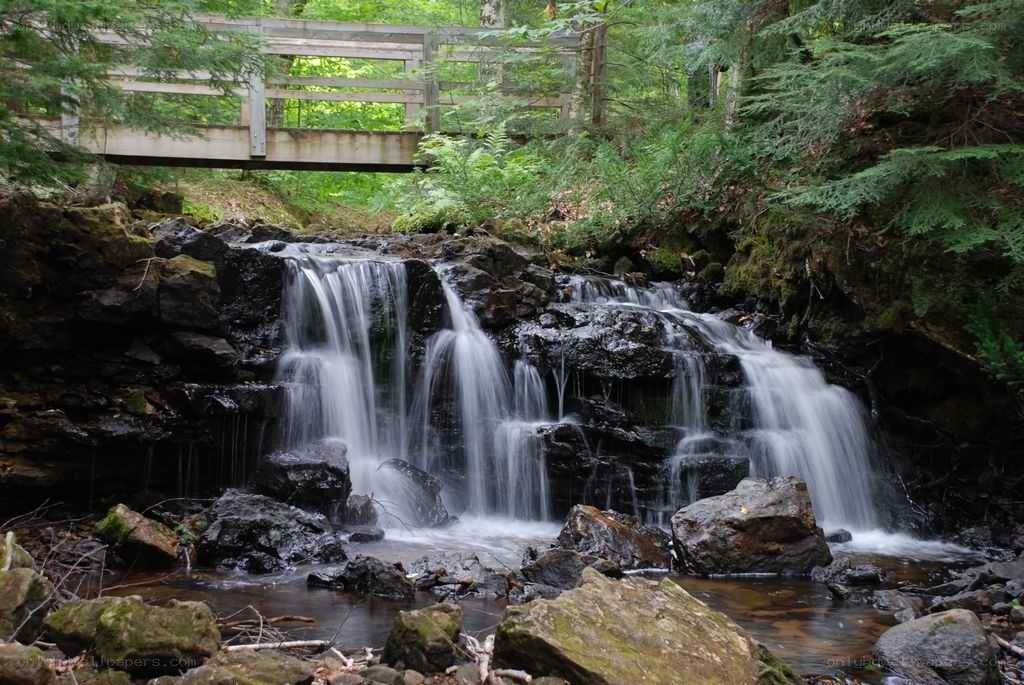 Waterfall under a wooden bridge