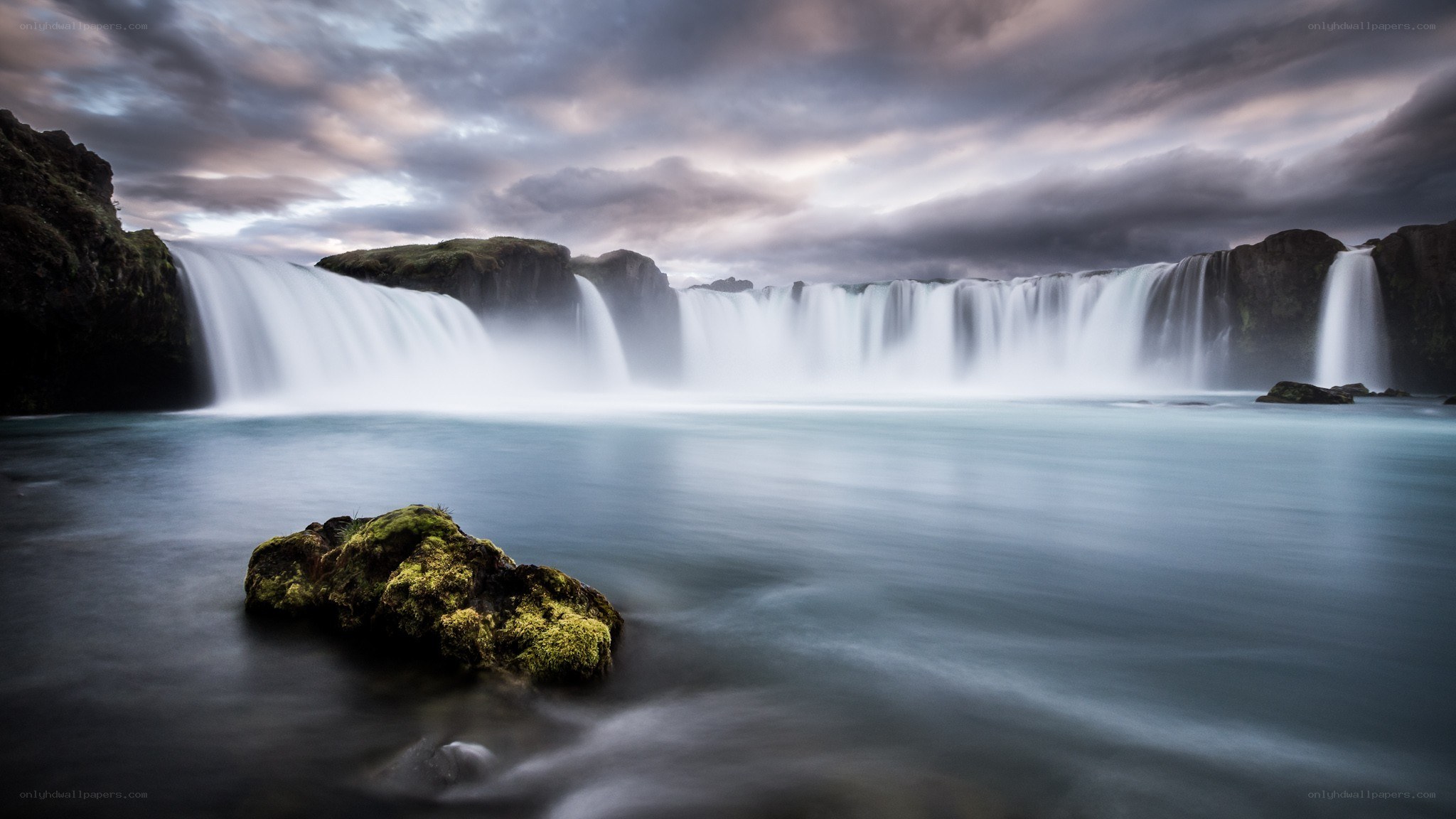 Waterfall under cloudy sky