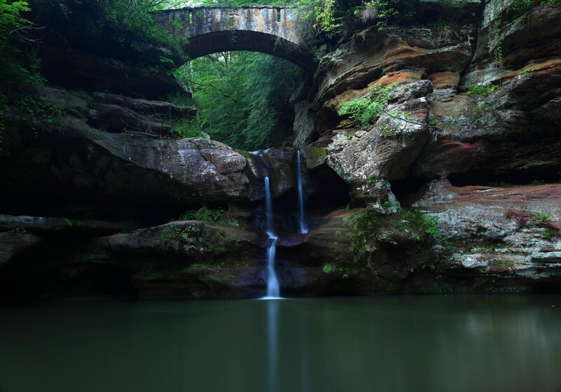 Waterfall under stone bridge