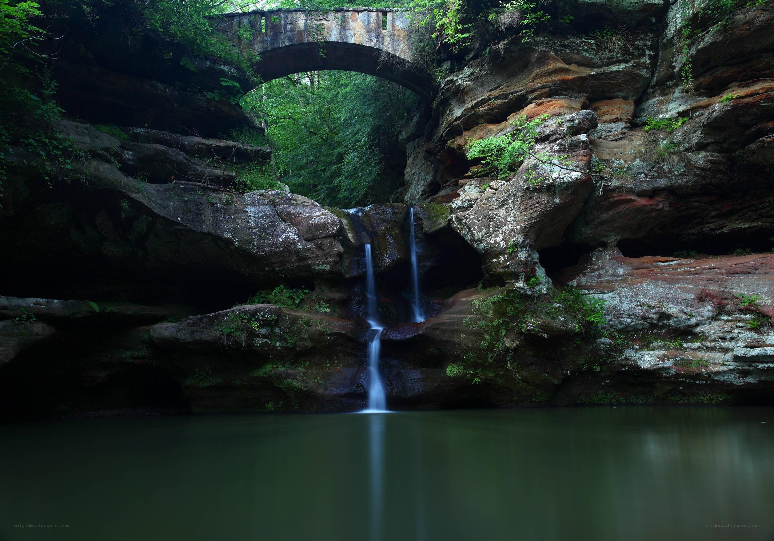 Waterfall under stone bridge