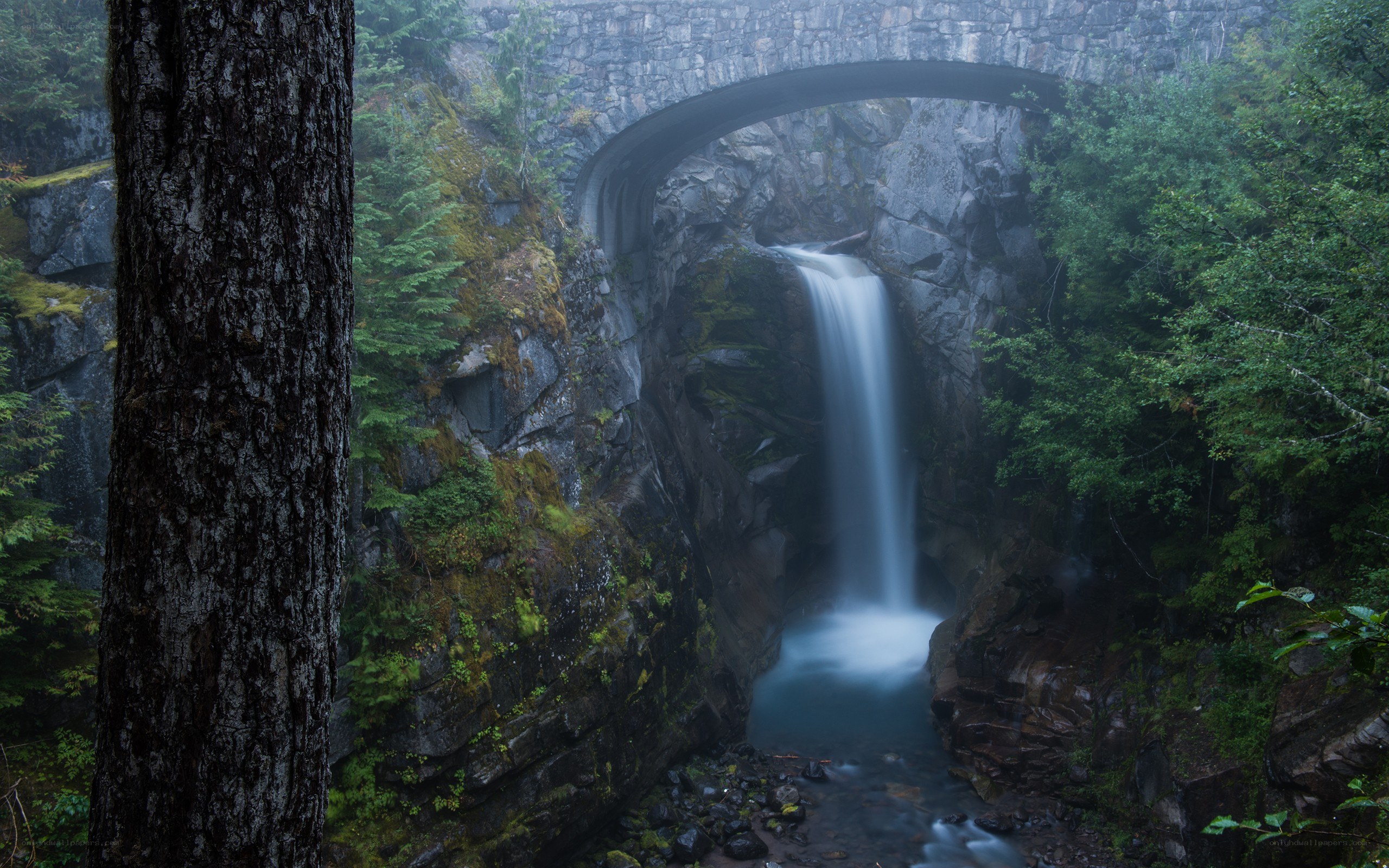 Waterfall under stone bridge
