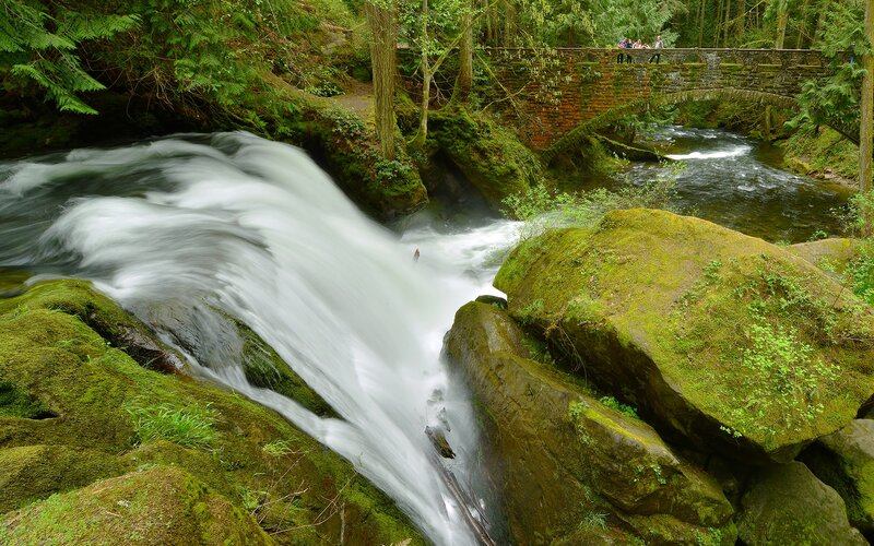 Waterfall under stone bridge