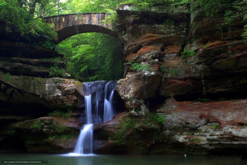 Waterfall under stone bridge