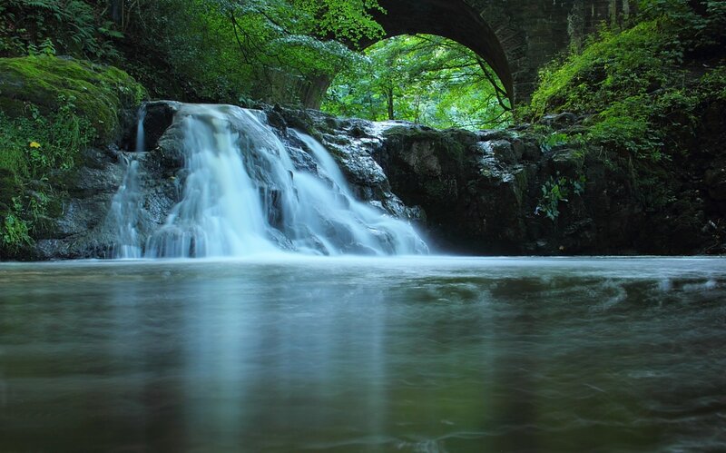 Waterfall under Stone Bridge — Green, Serene, Afternoon, Photograph, Trees, River, Blue