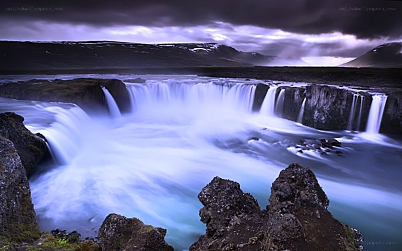 Waterfall under stormy sky