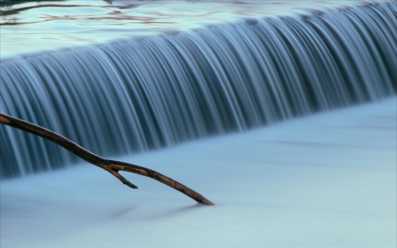 Waterfall with branch in foreground