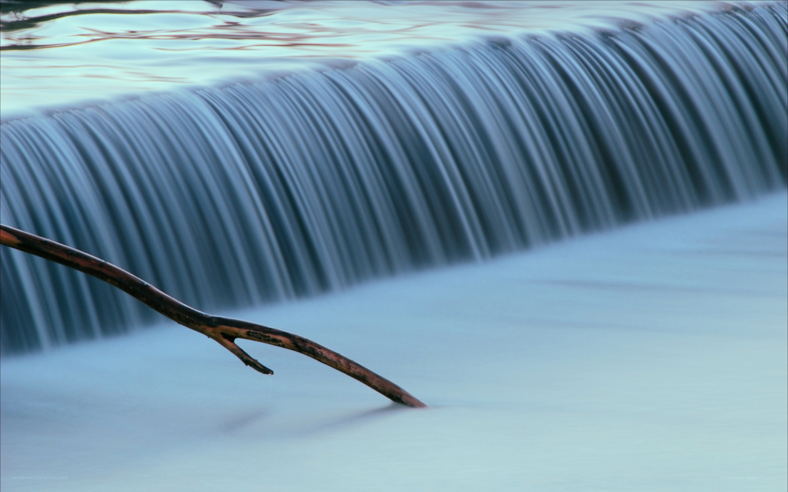 Waterfall with branch in foreground