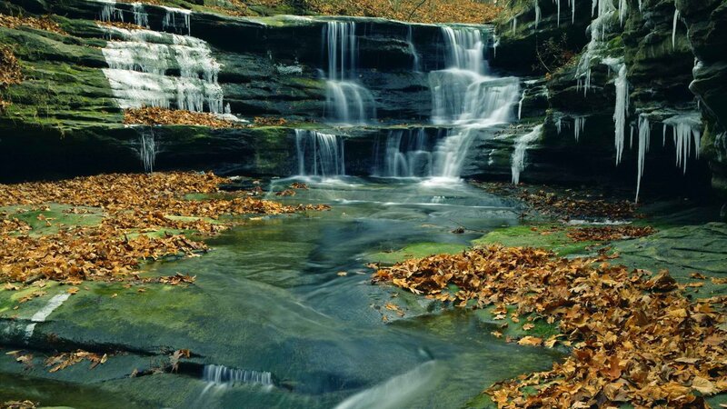 Waterfall with ice and autumn leaves