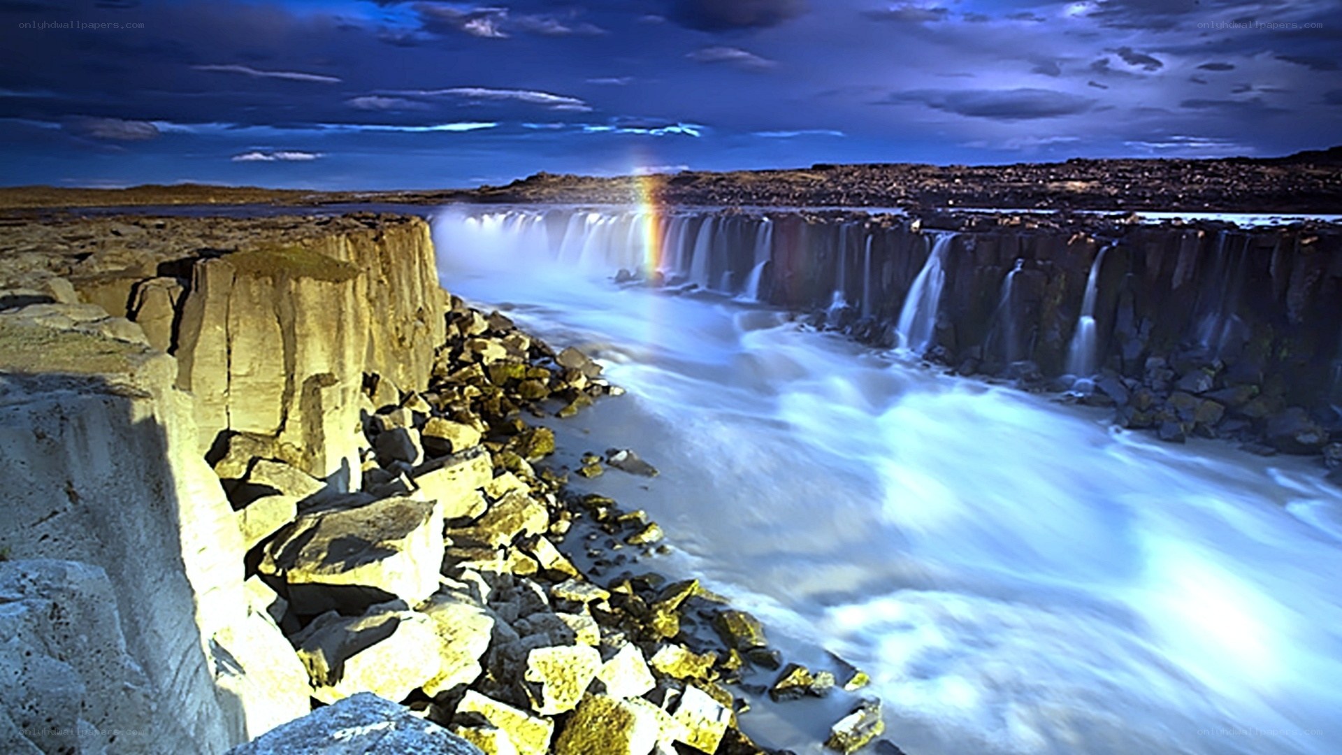 Waterfall with rainbow at dusk