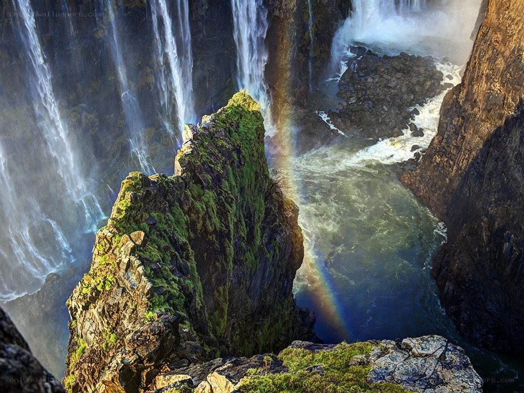 Waterfall with rainbow in canyon
