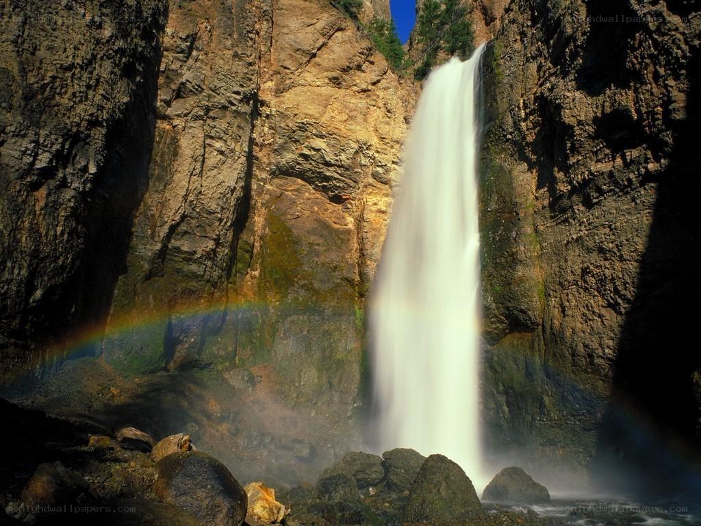 Waterfall with rainbow in canyon