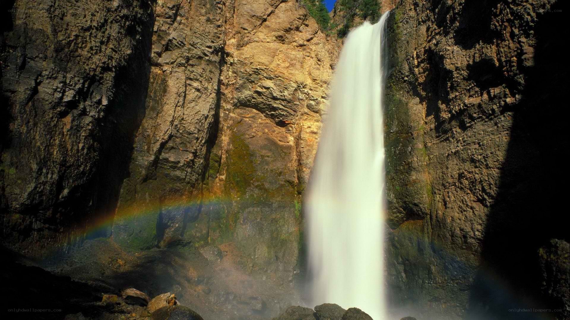 Waterfall with rainbow in canyon