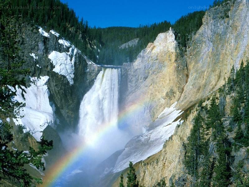 Waterfall with rainbow in canyon