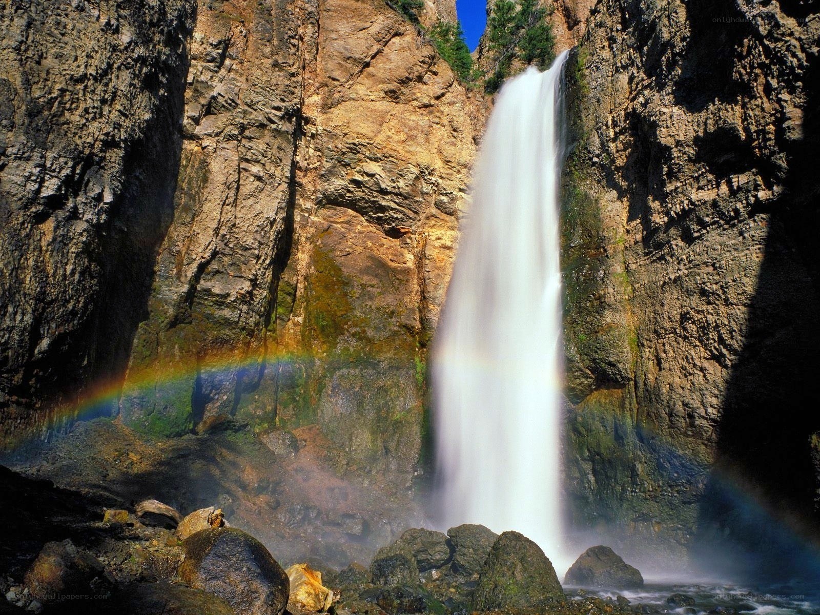 Waterfall with rainbow in canyon