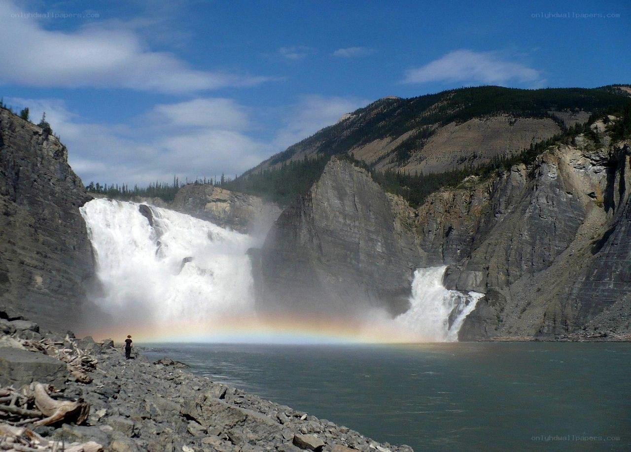 Waterfall with rainbow in canyon