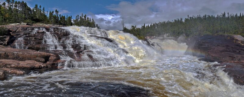 Waterfall with rainbow in forest