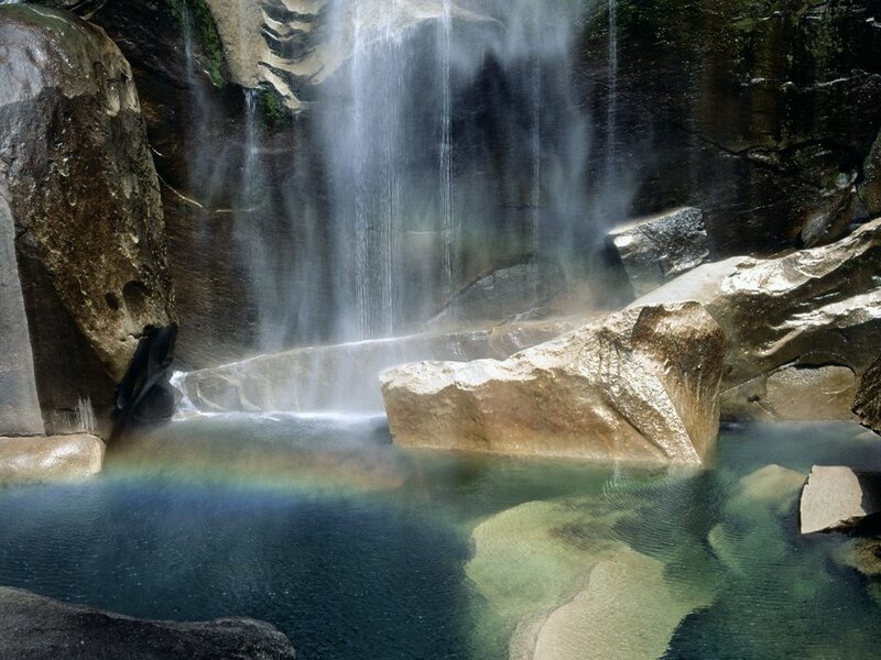 Waterfall with rainbow in pool