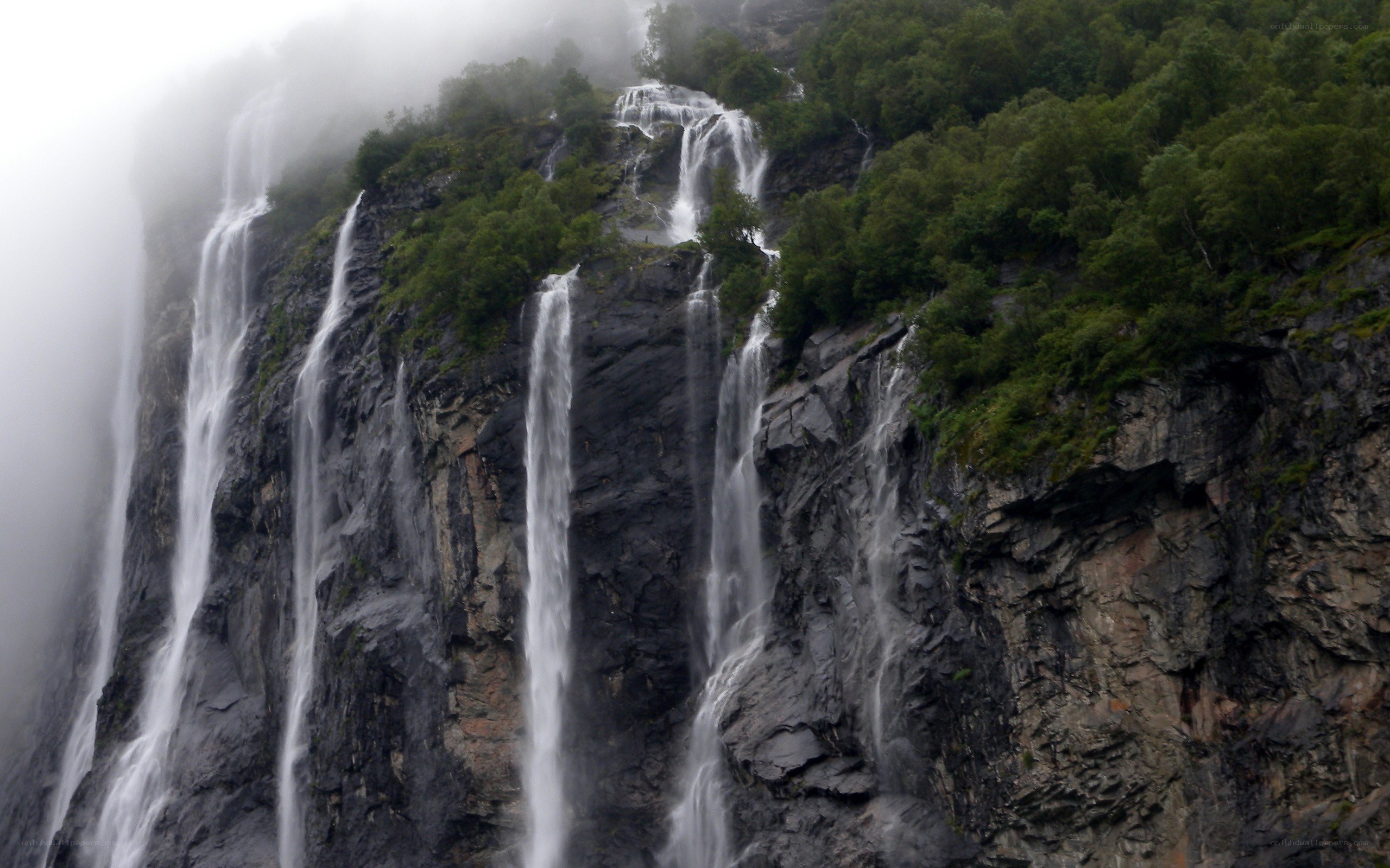 Waterfalls on a misty cliff