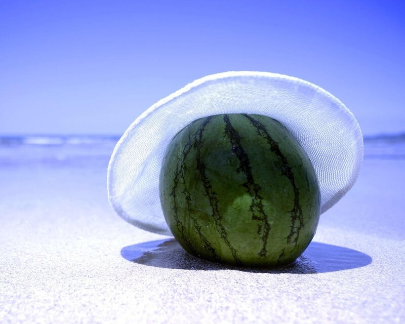 Watermelon on beach with hat