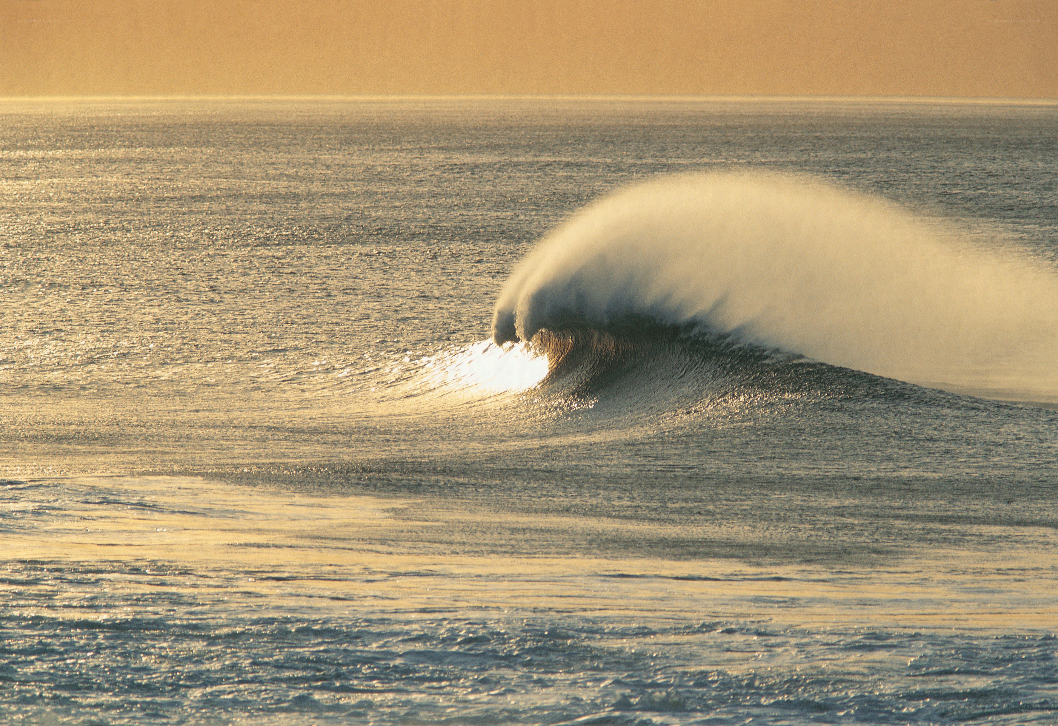 Wave breaking at sunset