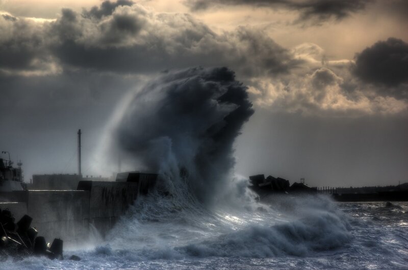 Wave crashes on harbor wall
