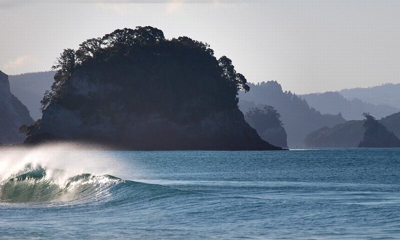 Wave crashing near rocky island
