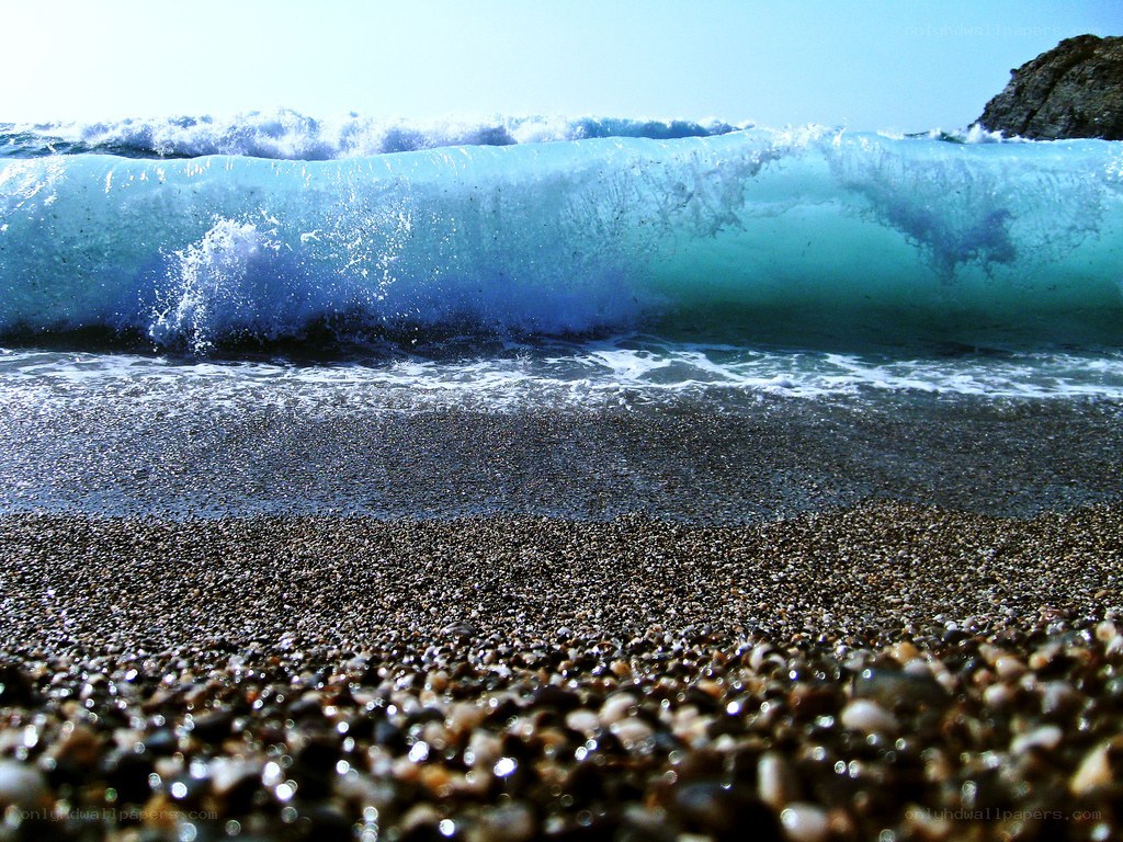 Wave crashing on pebble beach