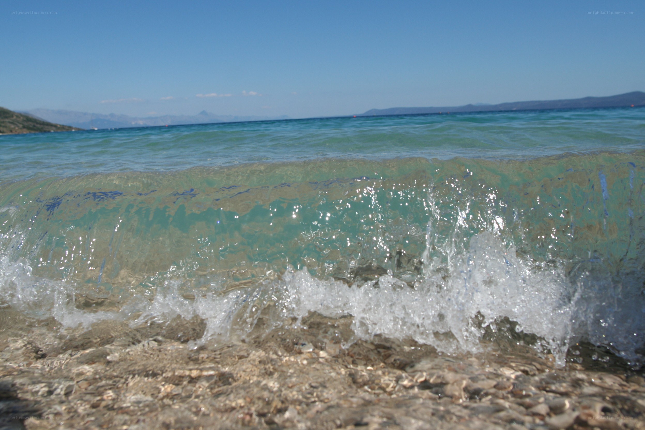 Wave crashing on pebbled shore