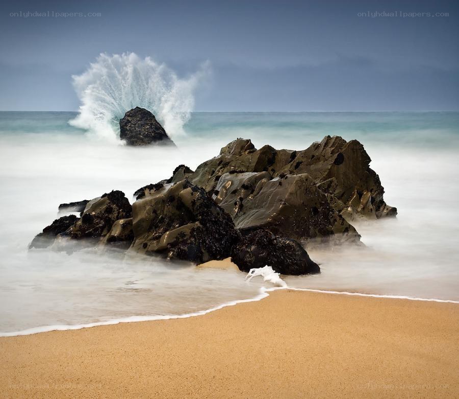 Wave crashing on rocks at beach