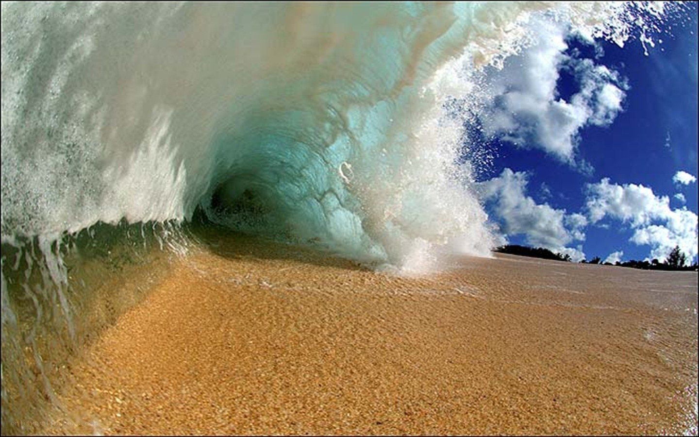 Wave crashing on sandy beach