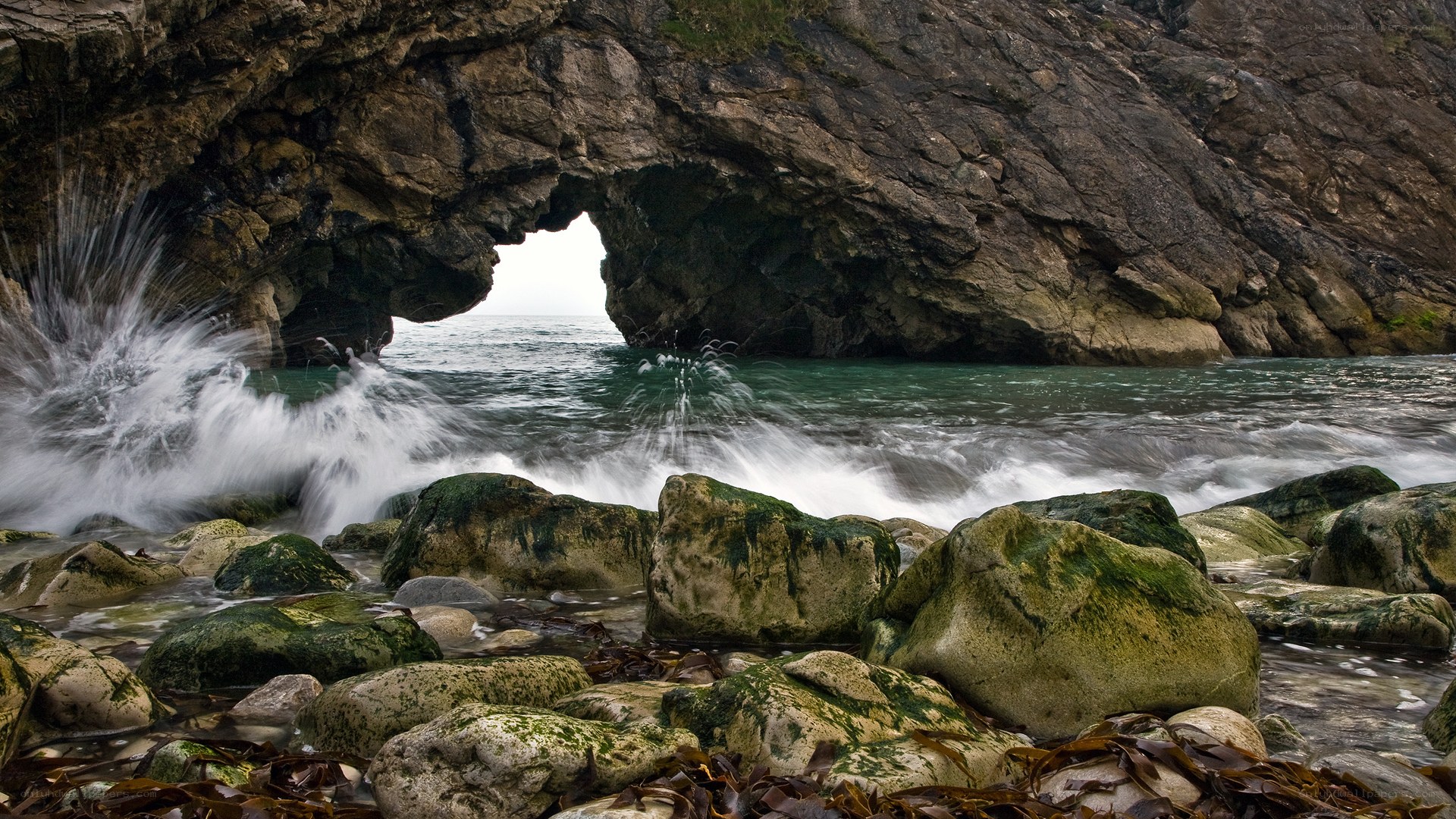 Wave crashing through sea arch