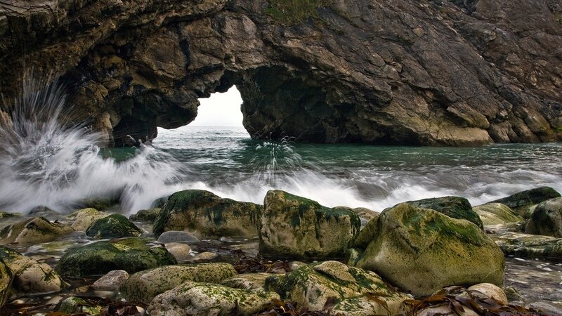 Wave crashing through sea arch