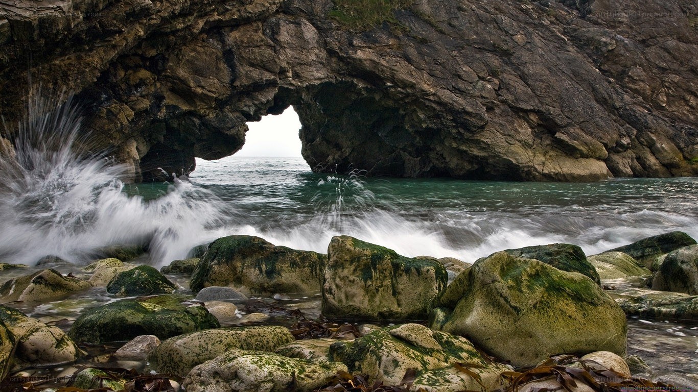 Wave crashing through sea arch