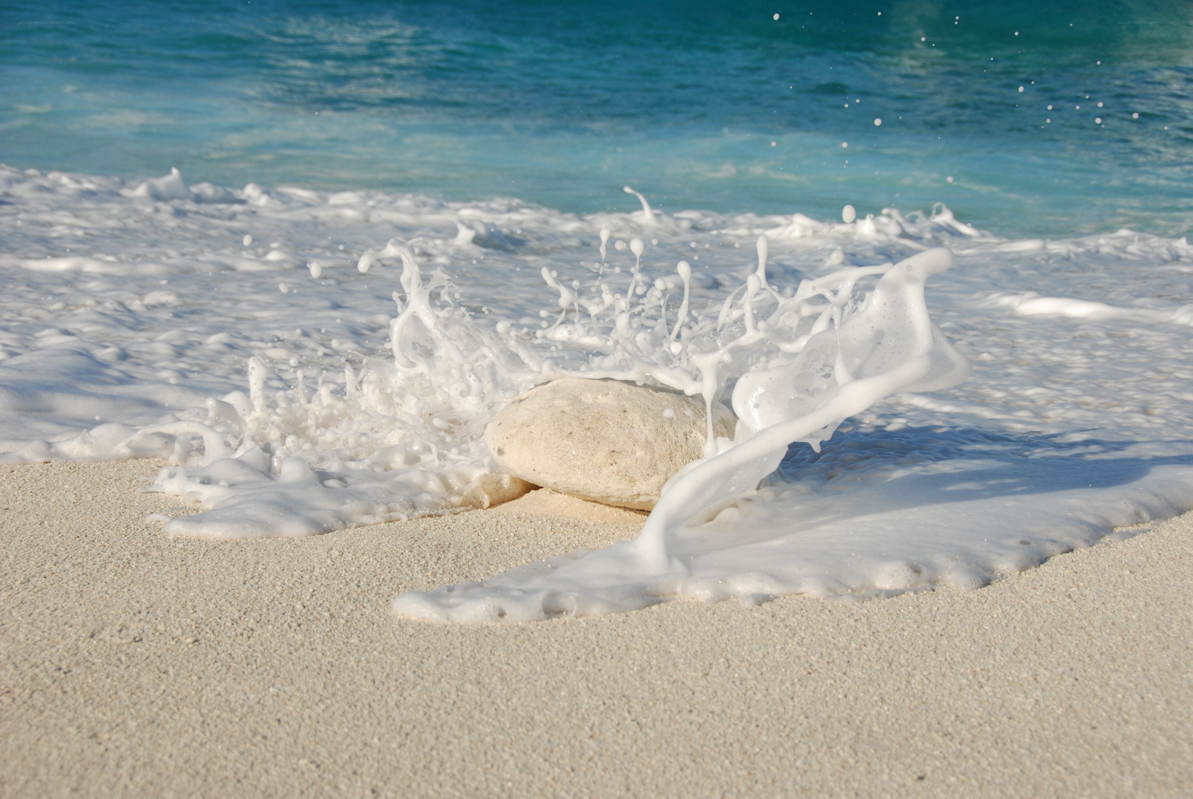 Wave splashing on beach rock