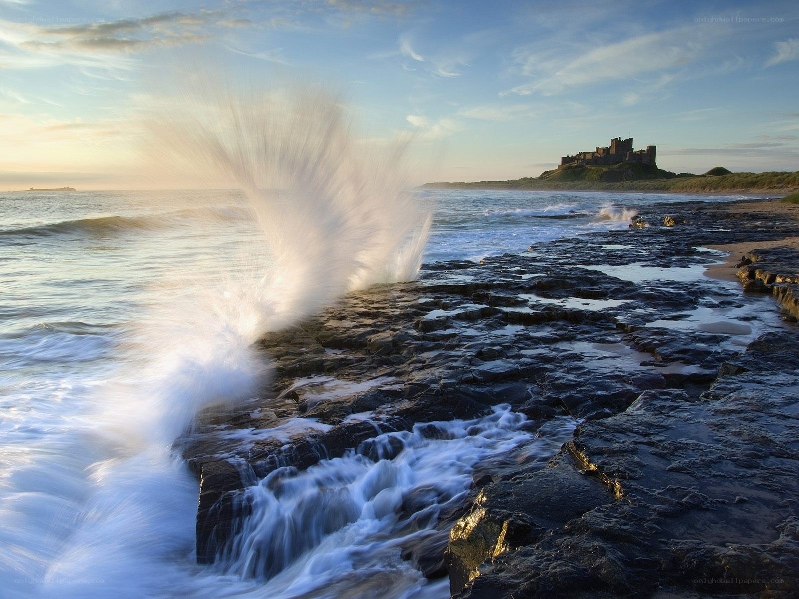 Waves crashing at Bamburgh Castle