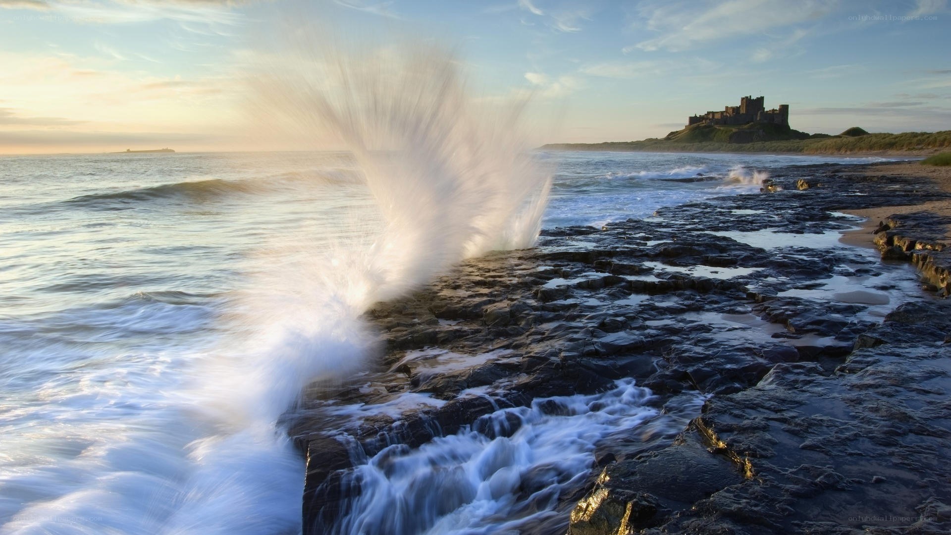 Waves crashing at Bamburgh Castle