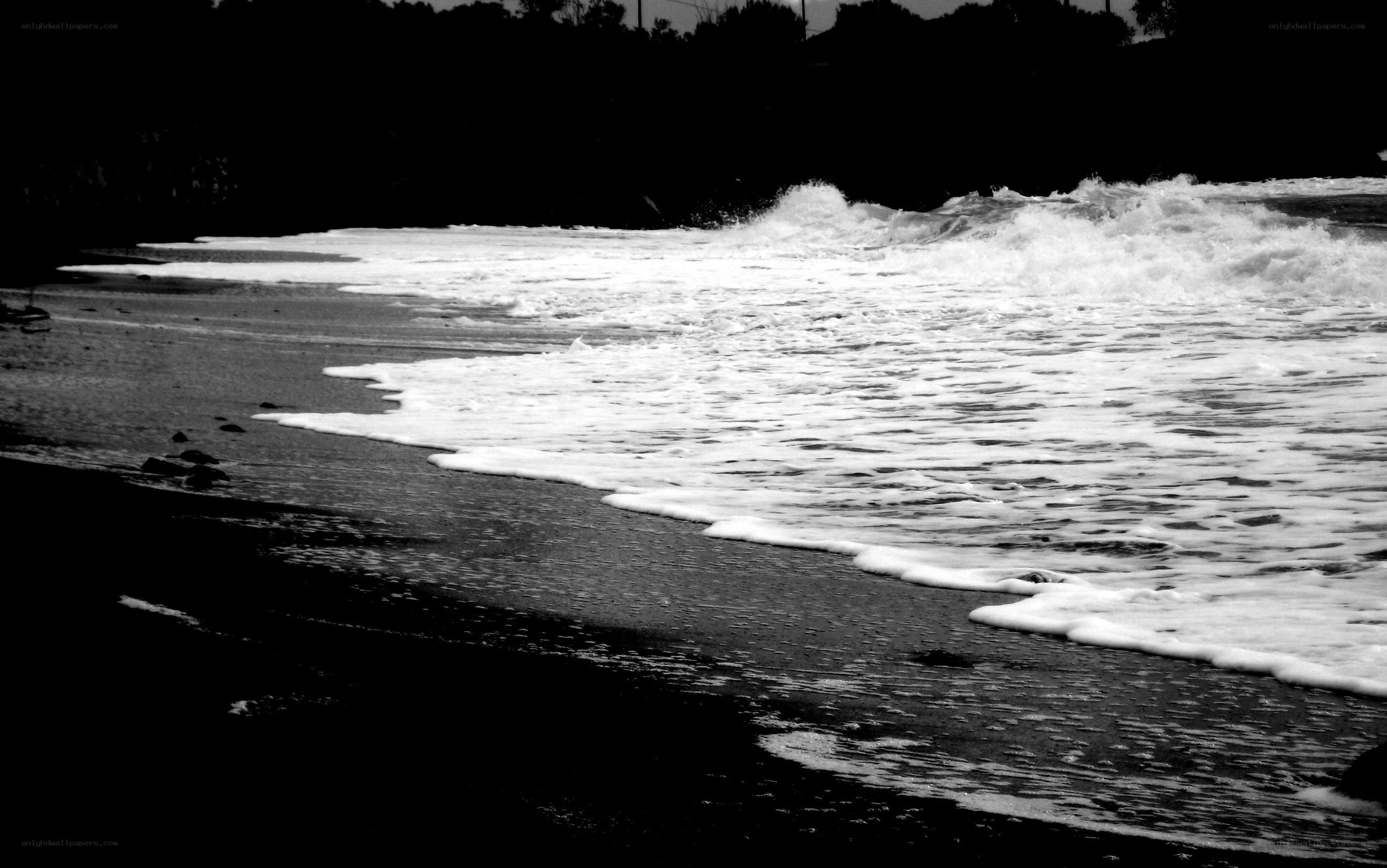 Waves crashing on a dark beach
